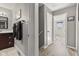 A bright hallway with neutral tones leads to a bathroom and bedroom with wood flooring at 7153 N Audubon Rd, Indianapolis, IN 46250