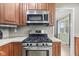 Updated kitchen showcasing stainless steel appliances, granite countertops, and wood cabinetry at 7153 N Audubon Rd, Indianapolis, IN 46250