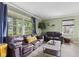 Bright living room with large windows, green walls, wood floors, and comfortable seating arrangement at 7153 N Audubon Rd, Indianapolis, IN 46250