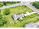 Aerial view of property showcasing the house, expansive lawn, mature trees, and convenient access to nearby roads at 7250 Hoover Rd, Indianapolis, IN 46260