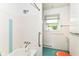 Cozy bathroom featuring a shower-tub combo and window at 7250 Hoover Rd, Indianapolis, IN 46260