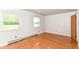 A light-filled bedroom with polished hardwood floors and natural light from two windows at 7250 Hoover Rd, Indianapolis, IN 46260