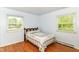Comfortable bedroom with hardwood floors, two windows, and soft natural light at 7250 Hoover Rd, Indianapolis, IN 46260