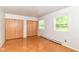 Bright bedroom with hardwood floors, two windows, and a closet at 7250 Hoover Rd, Indianapolis, IN 46260