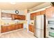 This is a warm kitchen with wooden cabinets, stainless steel appliances, and modern flooring at 7250 Hoover Rd, Indianapolis, IN 46260
