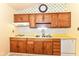 Traditional kitchen featuring wooden cabinets, white appliances, and decorative wallpaper at 7250 Hoover Rd, Indianapolis, IN 46260