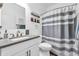 Stylish bathroom featuring a modern sink vanity, decorative mirror, and neutral colored shower curtain at 7897 Hickory Ridge Ln, Mooresville, IN 46158