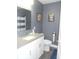 A clean bathroom featuring a vanity with a sink, toilet, and shower with blue striped curtains at 7897 Hickory Ridge Ln, Mooresville, IN 46158