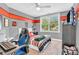 Stylish bedroom with a modern gamer chair, bed with red and gray bedding, and window with natural light at 7897 Hickory Ridge Ln, Mooresville, IN 46158