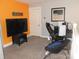 Bonus Room includes a television, computer desk and an orange accent wall at 7897 Hickory Ridge Ln, Mooresville, IN 46158