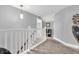 Hallway with gray carpet, a white wooden railing, gray walls, and decorative light fixture at 7897 Hickory Ridge Ln, Mooresville, IN 46158