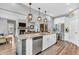 Open kitchen flows to living area with granite island, stainless appliances, and stylish pendant lighting at 7897 Hickory Ridge Ln, Mooresville, IN 46158