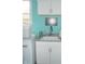 Bright laundry room with white cabinets, granite countertops, and modern washer and dryer at 7897 Hickory Ridge Ln, Mooresville, IN 46158