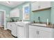 Well-lit laundry room with sink, granite counters and updated appliances for efficient chores at 7897 Hickory Ridge Ln, Mooresville, IN 46158