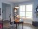 Bright office space featuring a wooden desk and chair, hardwood floors, and a large window at 7897 Hickory Ridge Ln, Mooresville, IN 46158