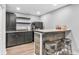 A finished basement boasts a modern wet bar with dark cabinetry and a countertop, perfect for entertainment at 7897 Hickory Ridge Ln, Mooresville, IN 46158