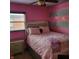 Bright bedroom with pink walls, striped accent wall, and cozy furnishings creating a charming and inviting space at 8136 E 37Th Pl, Indianapolis, IN 46226