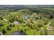 Aerial view showcasing a property with mature trees, a pond, outbuildings, and landscaping at 8245 Woodlawn Dr, Martinsville, IN 46151