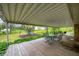 Covered deck with outdoor seating, a swing set, and a serene view of the expansive backyard at 8245 Woodlawn Dr, Martinsville, IN 46151