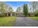 Beautiful home featuring stone accents, mature trees, a paved driveway, and well-maintained lawn at 8245 Woodlawn Dr, Martinsville, IN 46151