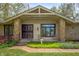 Inviting front porch with stone columns, decorative metal door, and manicured landscaping at 8245 Woodlawn Dr, Martinsville, IN 46151
