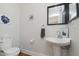 Chic powder room featuring a pedestal sink, modern fixtures, and a comfortable toilet at 825 Iowa St, Indianapolis, IN 46203