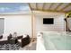 Hot tub area with mounted TV, seating, and shaded coverage, perfect for relaxing outdoors at 825 Iowa St, Indianapolis, IN 46203