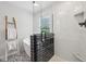 Bathroom with black and white tile, glass shower and soaking tub by the window at 877 Rosalind Pl, Carmel, IN 46032
