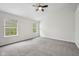 Spacious bedroom featuring neutral carpet, a ceiling fan, and two bright windows at 877 Rosalind Pl, Carmel, IN 46032