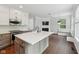 Open-concept kitchen with island flows into living area, complete with a cozy fireplace at 877 Rosalind Pl, Carmel, IN 46032
