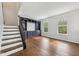 Bright living room featuring an elegant staircase, built-in shelving, and hardwood floors at 877 Rosalind Pl, Carmel, IN 46032