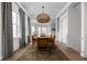 Dining room with wood floors, a jute pendant light, modern yellow chairs and gray curtains at 904 Veterans Way, Carmel, IN 46032