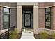 Charming front door with brickwork, transom window, and decorative floral wreath, creating a welcoming entrance at 904 Veterans Way, Carmel, IN 46032