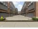Row of garages with gray doors, landscaping, and a paved alley at 904 Veterans Way, Carmel, IN 46032