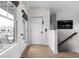 Bright hallway with a door to a balcony, stairs, and a wall-mounted TV at 904 Veterans Way, Carmel, IN 46032