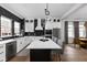 Modern kitchen features white cabinets, stainless steel appliances, a black backsplash, and island with bar seating at 904 Veterans Way, Carmel, IN 46032