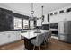 Bright, modern kitchen featuring stainless steel appliances, island seating, and statement lighting at 904 Veterans Way, Carmel, IN 46032