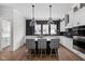 Bright, modern kitchen with stainless steel appliances, a kitchen island, and statement lighting at 904 Veterans Way, Carmel, IN 46032