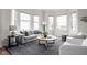 Living room showcases a neutral color palette, bay windows, and comfortable seating arrangement at 904 Veterans Way, Carmel, IN 46032