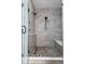 Stylish walk-in shower featuring pebble flooring, neutral tile, and a built-in bench at 904 Veterans Way, Carmel, IN 46032