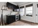 Convenient wet bar with modern black cabinets, mini-fridge, and marble countertop at 904 Veterans Way, Carmel, IN 46032