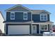 New construction two-story home features blue siding, white trim, attached two-car garage and covered porch at 9107 Steinbeck Ln, Indianapolis, IN 46239