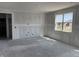 Unfinished living room boasts a bright window and bare concrete floors, ready for customization at 9107 Steinbeck Ln, Indianapolis, IN 46239