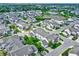 An aerial view of a residential neighborhood featuring well-maintained homes, tree-lined streets, and a serene pond at 9713 Springcress Dr, Noblesville, IN 46060