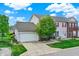 Charming two-story home with an attached garage, complemented by a lush green lawn and tidy landscaping at 9713 Springcress Dr, Noblesville, IN 46060