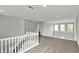 Upstairs hallway with railing overlooking the stairwell and backyard at 9713 Springcress Dr, Noblesville, IN 46060