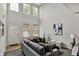Bright living room featuring high ceilings, large windows, and stylish gray furnishings at 9713 Springcress Dr, Noblesville, IN 46060