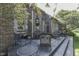 Wide angle view of a stone tiled back patio with seating area and brick house with unique detailing at 1014 Massey Ct, Greenwood, IN 46143