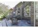 An outdoor stone tiled patio with seating, architectural detail, and a view of the lush landscaping at 1014 Massey Ct, Greenwood, IN 46143