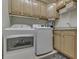 This laundry room has a washer, dryer, overhead cabinets, utility sink, and modern appliances at 1014 Massey Ct, Greenwood, IN 46143